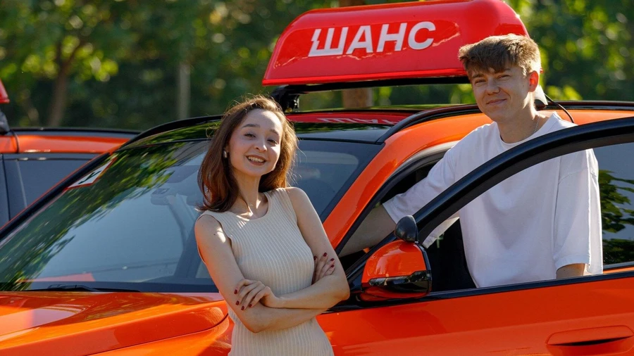 Девушка за рулём тревожно оглядывается, стоя на парковке